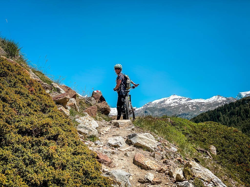Zermatt Biken - Couchflucht Sabrina Bechtold mit Mountainbike auf einem felsigen Trail