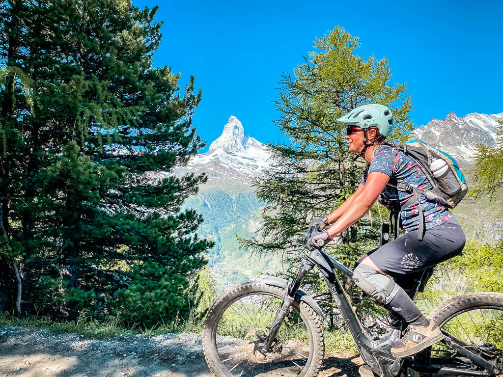 Couchflucht Sabrina Bechtold mit Mountainbike auf dem Blumenweg in Zermatt mit Blick auf das Matterhorn