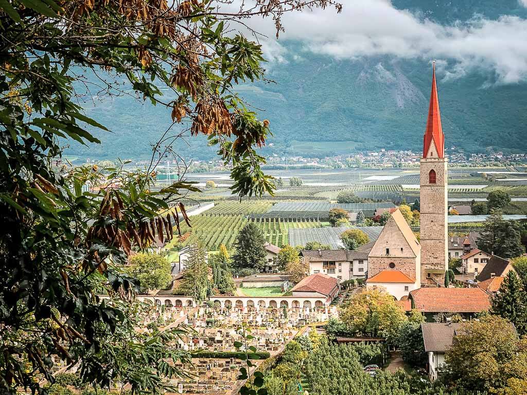 Ausblick auf Kirche, Weinberge und Obstplantagen auf dem Marlinger Waalweg