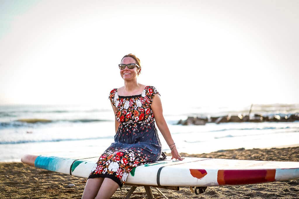 Couchflucht Sabrina Bechtold sitzt auf SUP am Strand vor dem Frosch Sportclub Il Tempio