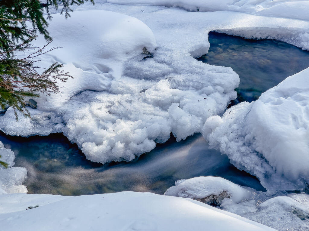 Winterurlaub in &Ouml;sterreich mit verschneitem Bach bei Saalbach Hinterglemm