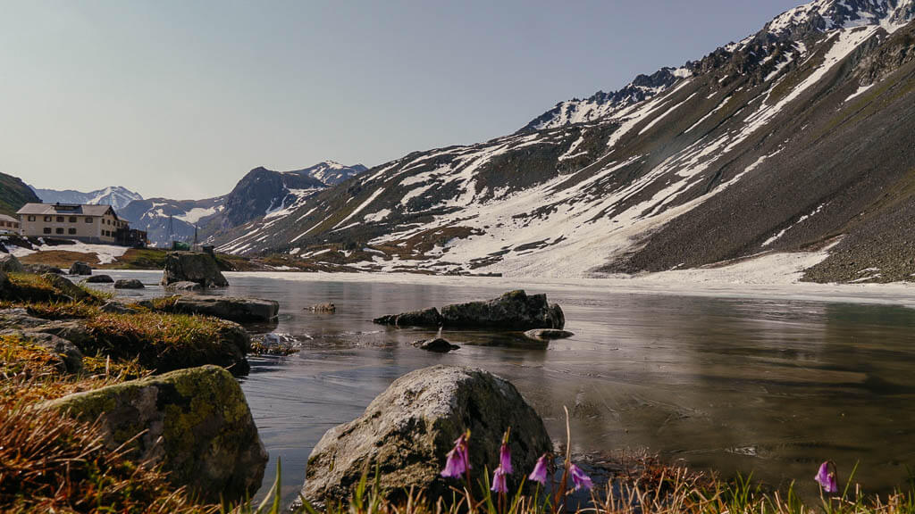 Grand Tour of Switzerland am Fl&uuml;elapass mit vereistem Bergsee