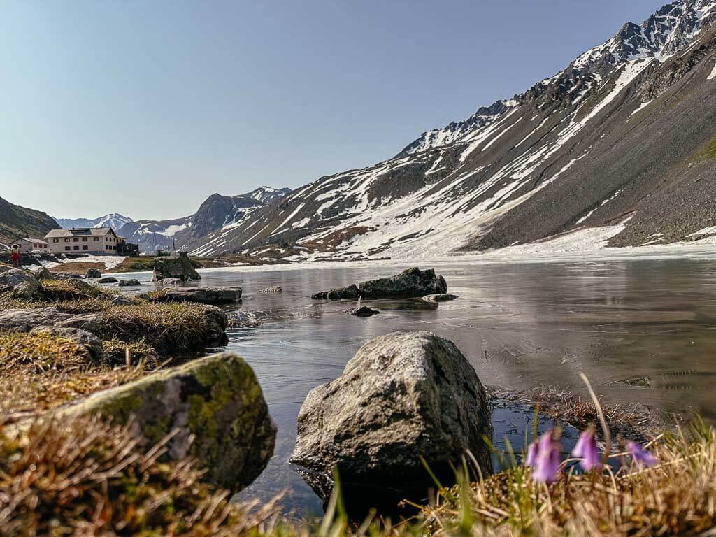 Grand Tour of Switzerland am Fl&uuml;elapass mit vereistem Bergsee